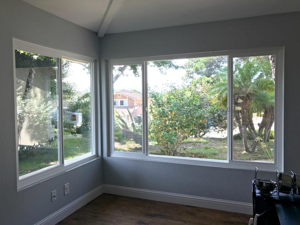 Before and after photos of our window replacement home improvement project. Not a DIY job for us but worth every penny of the cost. We went with vinyl windows instead of wood, and replaced the slider and screen instead of putting in french doors. Read the five biggest lessons we learned. #homeimprovement #diyproject #windows #interiordesign #investment #homedecor #beforeandafter